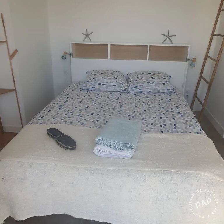 Chambre avec lit double et tête de lit en bois