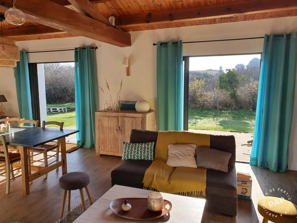 Salon avec baies vitrées ouvrant sur le jardin